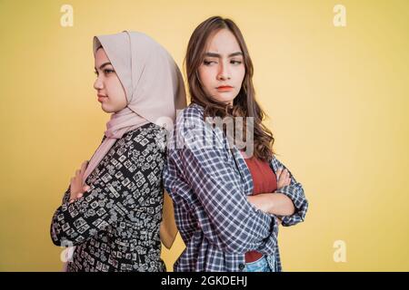 primo piano di due ragazze tristi che si levano in piedi indietro e incrociate le mani Foto Stock