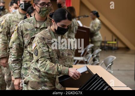 I soldati del 311° comando di sostegno (Expeditionary), recentemente tornati dal loro primo dispiegamento in Medio Oriente, ricevono le bandiere degli Stati Uniti in una cerimonia di benvenuto a casa Domenica, 21 marzo 2021 alla base di addestramento delle forze congiunte Los Alamitos, Calif. Foto Stock