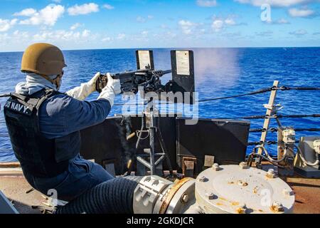 PHILLIPINE SEA (Mar. 22, 2021) – Master-at-Arms 1st Class Bryon Hunt, nativo di Reno Never., equipaggia la mitragliatrice del calibro di 0,50 durante un esercizio di fuoco vivo sul cacciatorpediniere missilistico guidato di classe Arleigh-Burke USS Barry (DDG 52). Barry è assegnato alla Task Force 71/Destroyer Squadron (DESRON 15), la più grande DESRON dispiegata in avanti della Marina e la principale forza di superficie della 7a flotta statunitense. Foto Stock