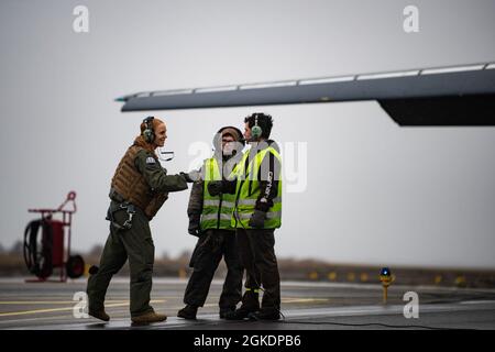 Un pilota assegnato al 9° Squadrone della Bomba di spedizione saluta due capi dell'equipaggio alla stazione dell'aeronautica di Ørland, Norvegia, 23 marzo 2021. Due B-1s hanno partecipato ad Amalgam Dart, una missione di formazione congiunta sull'integrazione che consiste in una serie di potenziali scenari reali progettati per rafforzare l'allerta aerospaziale degli Stati Uniti e la disponibilità alla difesa. Foto Stock