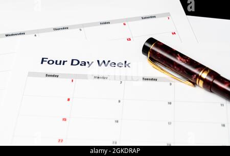 Calendario stampato per una settimana lavorativa di 4 giorni che mostra i giorni del fine settimana in rosso in un nuovo approccio alla produttività Foto Stock