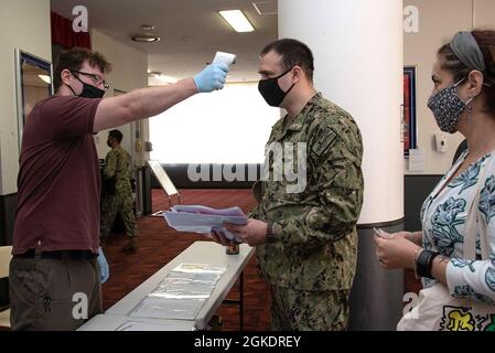 YOKOSUKA, Giappone (24 marzo 2021) — Lt. CMdR. Ben Sheldon, assegnato al Comandante, Gruppo sottomarino 7, ottiene la sua temperatura presa da Master-at-Arms 1a classe Roderick Dexter, attaccato al Comandante, Fleet Activities Yokosuka s (CFAY) Dipartimento di sicurezza all'ingresso del Fleet Theatre durante l'evento di imposta su strada di base. Questo evento di tre giorni, dal 24 al 26 marzo, offre un servizio di pagamento fiscale semplice e rapido per i proprietari di auto e motociclette. Per oltre 75 anni, CFAY ha fornito, mantenuto e gestito strutture e servizi di base a supporto del 7° dipartimento della flotta statunitense Foto Stock