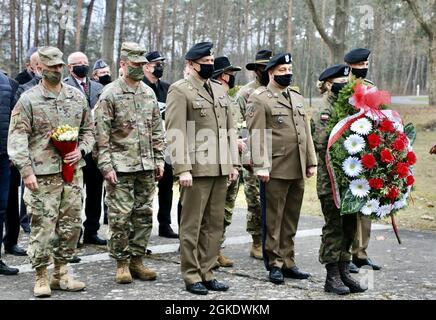 Ricardo Roig (estrema sinistra, con fiori), comandante del 50° gruppo di supporto regionale (RSG) e comando Sgt. Robert Sweat (secondo da sinistra in uniforme camouflage), 50esimo comandante RSG maggiore, partecipa a una cerimonia di commemorazione a Zagan, in Polonia, il 24 marzo 2021, con rappresentanti delle milizie polacche e americane, nonché di funzionari locali. La cerimonia commemora gli sforzi dei membri del servizio alleato che hanno partecipato alla “Grande fuga” di Stalag Luft III, un campo tedesco di prigionia di guerra, nel marzo 1942. Il 50 ° RSG, un'unità della Guardia Florida con sede a Homestead, Florida, è Foto Stock