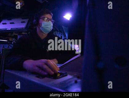 210325-N-VD554-1187 OCEANO PACIFICO (25 marzo 2021) – Cryptologic Technician (Technical) 2nd Class Thomas A. Joyce, di Durham, Conn., guarda in un centro di informazione sul combattimento durante un ambiente di addestramento integrato a bordo del cacciatorpediniere missilistico guidato di classe Arleigh USS Rafael Peralta (DDG 115). Rafael Peralta è assegnato alla Task Force 71/Destroyer Squadron (DESRON) 15, la più grande DESRON dispiegata in avanti della Marina e la principale forza di superficie della 7a flotta statunitense. Foto Stock