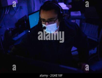 210325-N-VD554-1183 OCEANO PACIFICO (25 marzo 2021) – Cryptologic Technician (Technical) 2a classe Justin Rhodes, di Phoenix, N.Y., guarda in un centro di informazioni sul combattimento durante un ambiente di addestramento integrato a bordo del cacciatorpediniere missilistico guidato di classe Arleigh USS Rafael Peralta (DDG 115). Rafael Peralta è assegnato alla Task Force 71/Destroyer Squadron (DESRON) 15, la più grande DESRON dispiegata in avanti della Marina e la principale forza di superficie della 7a flotta statunitense. Foto Stock