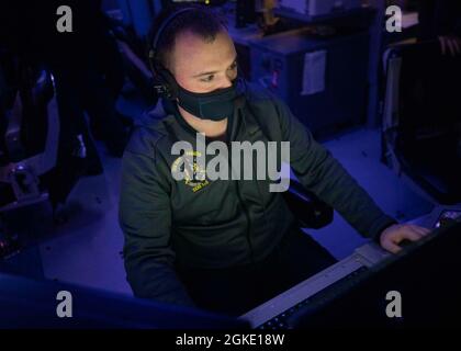 210325-N-VD554-1176 OCEANO PACIFICO (25 marzo 2021) – Fire Controlman (Aegis) 2a classe Alexander Fallion, di Georgetown, Texas, si alza in guardia nel centro di informazioni sul combattimento durante un ambiente di addestramento integrato a bordo del cacciatorpediniere missile guidato di classe Arleigh USS Rafael Peralta (DDG 115). Rafael Peralta è assegnato alla Task Force 71/Destroyer Squadron (DESRON) 15, la più grande DESRON dispiegata in avanti della Marina e la principale forza di superficie della 7a flotta statunitense. Foto Stock