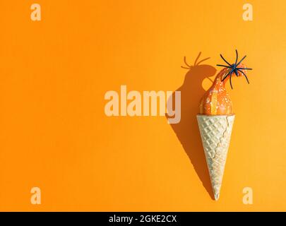 zucca piccola e ragno in un cono gelato con spazio copia. tema halloween, autunno Foto Stock