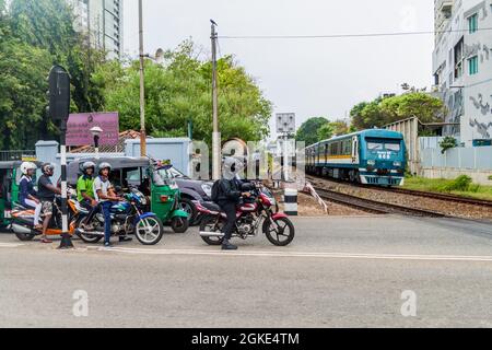 COLOMBO, SRI LANKA - 26 LUGLIO 2016: I conducenti aspettano ad un incrocio ferroviario a Colombo, Sri Lanka Foto Stock