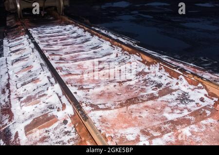 I resti di nitrato di ammonio bianco, fertilizzanti quando si scarica un carro su binari ferroviari. Foto Stock
