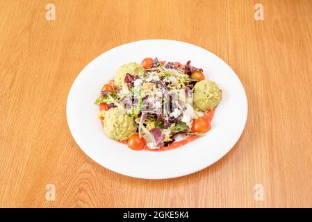 insalata di germogli di lattuga, pomodori ciliegini, polpette di guacamole e formaggio grattugiato Foto Stock