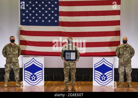 Master Sgt. Christina Ford, 436th Force Support Squadron Career Assistance ADVISOR, si trova tra il col. Matthew Jones, 436th Airlift Wing Commander, Left, e Chief Master Sgt. Jeremiah Grisham, capo del comando ad interim della 436a AW, mentre posano per una foto durante la cerimonia di rilascio della promozione del maestro sergente tenuta al teatro di base sulla base dell'aeronautica militare di dover, Delaware, 26 marzo 2021. Ford è stato uno dei 10 master sergeants di dover AFB selezionati per la promozione al master sergeant senior nel ciclo di promozione 21E8. Foto Stock