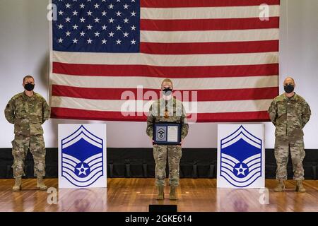 Master Sgt. Jessica Nienhueser, 436esimo sovrintendente di Squadron del supporto medico, si trova tra il col. Matthew Jones, 436esimo comandante dell'Ala dell'Airlift, a sinistra, e capo maestro Sgt. Jeremiah Grisham, capo del comando ad interim della 436a AW, mentre posano per una foto durante la cerimonia di rilascio della promozione del maestro sergente tenuta al teatro di base sulla base dell'aeronautica militare di dover, Delaware, 26 marzo 2021. Nienhueser è stato uno dei 10 master sergeant di dover AFB selezionati per la promozione al master sergeant senior nel ciclo di promozione 21E8. Foto Stock