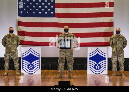 Master Sgt. Jason Karras, 436th Logistics Readiness Squadron alimenta il sovrintendente di volo di gestione, si trova tra il col. Matthew Jones, 436th Airlift Wing Commander, left, e Chief Master Sgt. Jeremiah Grisham, capo del comando ad interim della 436a AW, mentre posano per una foto durante la cerimonia di rilascio della promozione del maestro sergente tenuta al teatro di base sulla base dell'aeronautica militare di dover, Delaware, 26 marzo 2021. Karras è stato uno dei 10 master sergeant di dover AFB selezionati per la promozione al master sergeant senior nel ciclo di promozione 21E8. Foto Stock