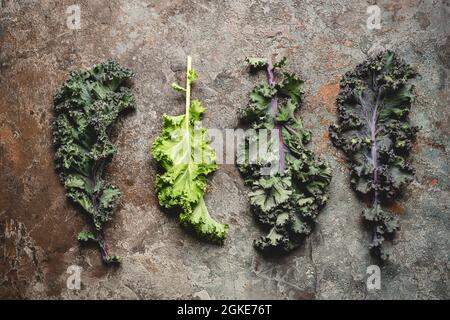 Kale lascia la verdura super su sfondo di pietra grigia, vista dall'alto Foto Stock