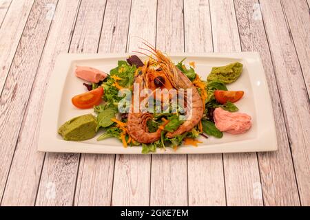 insalata di fusione di avocado, crema di fragole, carota e germogli di lattuga assortiti e gamberi alla griglia Foto Stock