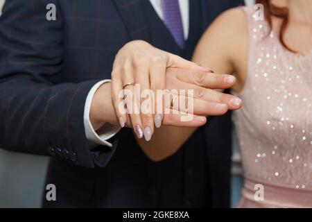 Mani di sposi innamorati degli anelli di nozze Foto Stock