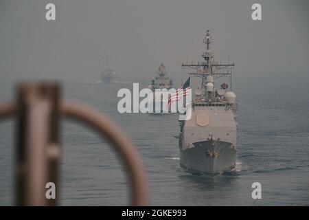 OCEANO INDIANO (28 marzo 2021) – l'incrociatore missilistico guidato di classe Ticonderoga USS Bunker Hill (CG 52), di fronte, la fregata missilistica guidata di classe Shivalik della Marina indiana IN Shivalik (F47), a metà strada, E il cacciatorpediniere missilistico guidato di classe Arleigh Burke USS Russell (DDG 59), veleggia in formazione dietro la portaerei USS Theodore Roosevelt (CVN 71) il 28 marzo 2021. Il gruppo Theodore Roosevelt Carrier Strike è in fase di dispiegamento programmato per l'area operativa della 7a flotta statunitense. Come la più grande flotta della Marina statunitense, 7th Fleet opera regolarmente e interagisce con 35 nazioni marittime Foto Stock