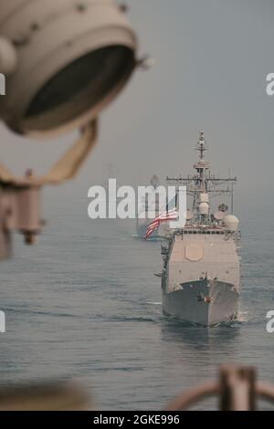 OCEANO INDIANO (28 marzo 2021) – l'incrociatore missilistico guidato di classe Ticonderoga USS Bunker Hill (CG 52), fronte, La fregata missilistica guidata di classe Shivalik della Marina indiana, IN Shivalik (F47), Middle, e il cacciatorpediniere missilistico guidato di classe Arleigh Burke USS Russell (DDG 59), navigano in formazione dietro la portaerei USS Theodore Roosevelt (CVN 71) il 28 marzo 2021. Il gruppo Theodore Roosevelt Carrier Strike è in fase di dispiegamento programmato per l'area operativa della 7a flotta statunitense. Come la flotta più grande della Marina statunitense, 7th Fleet opera e interagisce di routine con 35 nazioni marittime wh Foto Stock