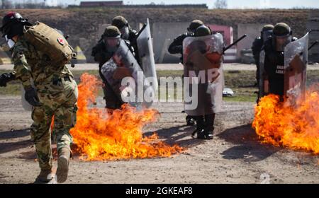 Fiamme scoppiate sul terreno come un soldato ungherese delle forze di difesa assegnato al comando regionale-Est, la forza del Kosovo, lancia una bottiglia di fuoco durante l'addestramento di fobia del fuoco a Camp Marechal de Lattre de Tassigny, Kosovo, il 29 marzo 2021. Le truppe addestrarono il contingente polacco della KFOR in un ambiente controllato. La formazione è fondamentale per contribuire a mantenere un ambiente sicuro e sicuro per tutte le persone in Kosovo. Foto Stock