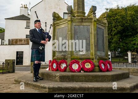 Un piper suona le cornamuse al monumento commemorativo di guerra commemora il giorno di San Valery quando i soldati scozzesi sono stati catturati nella seconda guerra mondiale, Berwick settentrionale, Scozia, Regno Unito Foto Stock