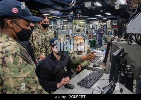 210330-N-BT681-1006 SASEBO, Giappone (30 marzo 2021) i marinai con sede a Sasebo partecipano alla formazione del sistema di comando e controllo globale a bordo della nave da assalto anfibio USS America (LHA 6) nel Combat Information Center della nave. Gli istruttori del Center for Surface Combat Systems Detachment Yokosuka hanno offerto corsi di formazione a diverse navi sul mare. L'America, nave principale dell'America Amphibious Ready Group, insieme alla 31st Marine Expeditionary Unit, sta operando nell'area di responsabilità della 7th Fleet statunitense per migliorare l'interoperabilità con alleati e partner e fungere da forza di risposta pronta al def Foto Stock