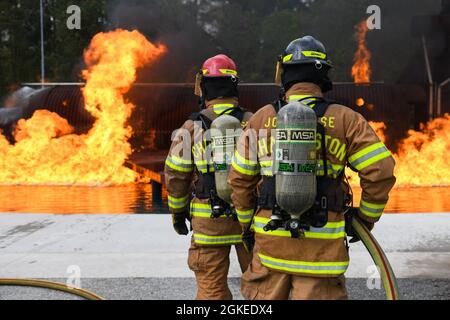 I vigili del fuoco assegnati al 628° Squadron dell'ingegnere civile prendono parte a un esercizio di combustione dal vivo il 30 marzo 2021 presso la Joint base Charleston, S.C. gli specialisti della protezione antincendio partecipano a questo esercizio ogni tre mesi per rinnovare la loro preparazione alla formazione. Il sito di addestramento è l'unico luogo disponibile con capacità di incendio simulate su Joint base Charleston. Foto Stock