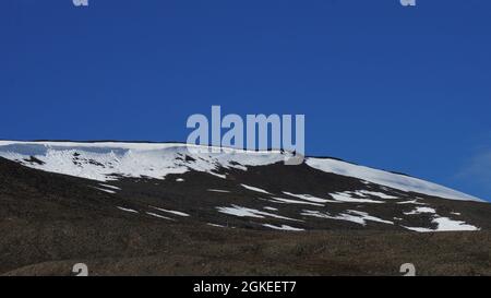 la linea dura che separa terra e cielo in una montagna e cielo ghiacciati e nevosi. A Longyearbyen, a Spitsbergen in Norvegia Foto Stock
