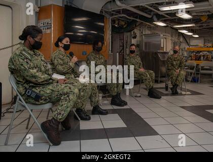 210331-N-JX361-1041 YOKOSUKA, Giappone (31 marzo 2021) il Master-at-Arms Jessica Guzman racconta una storia sulla sua carriera durante una tavola rotonda “Donne di Reagan” sui ponti di caos in avanti dell’unica portaerei dispiegata in avanti della Marina degli Stati Uniti, USS Ronald Reagan (CVN 76). Il panel è stato un evento culminante per il mese della storia delle donne e ha fornito una piattaforma per le donne leader senior assegnate a Ronald Reagan per condividere i momenti salienti della loro carriera militare con i marinai. Ronald Reagan, l'ammiraglia del Carrier Strike Group 5, fornisce una forza pronta per i combattimenti che protegge e difende l'Unite Foto Stock