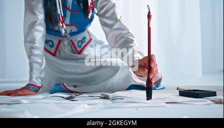 Una donna sta dipingendo una calligrafia cinese Foto Stock