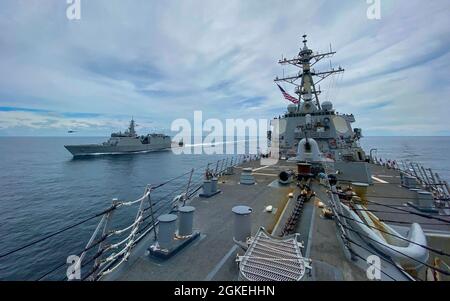 OCEANO INDIANO (31 marzo 2021) il cacciatorpediniere missilistico guidato di classe Arleigh Burke USS Russell (DDG 59), davanti, transita accanto alla nave di pattuglia di classe Saryu della Marina indiana A Sumitra (P59) durante un esercizio di passaggio 31 marzo 2021. Russell, parte del gruppo Theodore Roosevelt Carrier Strike Group, è in fase di implementazione nell'area operativa della 7a flotta statunitense. Come la più grande flotta della Marina degli Stati Uniti, la settima flotta opera e interagisce regolarmente con 35 nazioni marittime, conducendo missioni per preservare e proteggere una regione indopacifica libera e aperta. Foto Stock