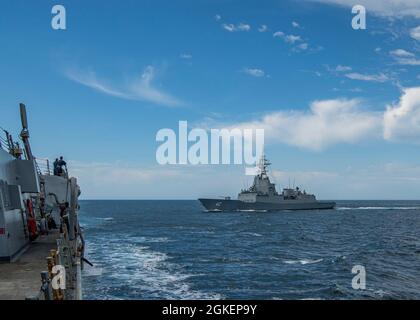 OCEANO PACIFICO (1 aprile 2021) il cacciatorpediniere missilistico guidato di classe Arleigh Burke USS John Finn (DDG 113), a sinistra, transita con il cacciatorpediniere di classe Hobart della Royal Australian Navy HMAS Sydney (DDG 42) 1 aprile 2021. John Finn sta conducendo le operazioni di routine nella terza flotta degli Stati Uniti. Foto Stock