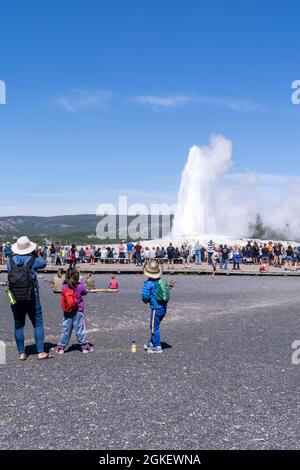 Wyoming, USA - 10 agosto 2021: Folle di turisti aspettano lungo le passerelle per far esplodere Old Faithful nel Parco Nazionale di Yellowstone Foto Stock