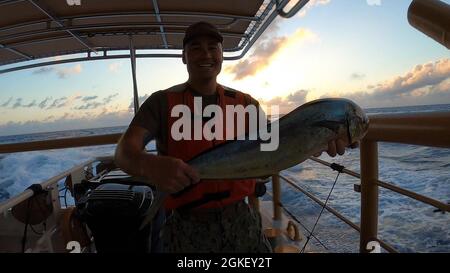 OCEANO ATLANTICO (2 aprile 2021) Petty Officer di prima classe Derek Zillinger mostra il Mahi Mahi che ha catturato durante una chiamata di pesce a bordo di USCGC Charles Moltrope (WPC 1141) nell'Oceano Atlantico il 2 aprile 2021. L'USCGC Charles Molthrope (WPC 1141) e l'USCGC Robert Goldman (WPC 1142) sono sulla strada per il loro nuovo homeport in Bahrain a sostegno della Quinta flotta della Marina degli Stati Uniti e delle forze di pattuglia della Guardia Costiera degli Stati Uniti nell'Asia sud-occidentale. Mentre nella Sesta area di responsabilità della flotta della Marina degli Stati Uniti, gli equipaggi sosterranno gli impegni con i paesi partner rafforzando le relazioni e dimostrando la nostra continuazione Foto Stock