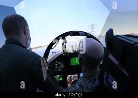 Lt. CMdR. Kurt Garman, Carrier Air Wing (CVW) 5 Landing Signals Officer, sinistra, briefing Vice ADM. Bill Merz, comandante, U.S. 7th Fleet durante una visita al complesso di addestramento operativo (OTC) fa-18 Simulator come parte di un tour di MCAS Iwakuni, Giappone, 2 aprile. Lo scopo della visita era quello di concentrarsi sull'impegno con le forze navali schierate in avanti come Carrier Air Wing (CVW) 5 che supportano le operazioni del Carrier Strike Group (CSG) 5 e della U.S. 7th Fleet. Foto Stock