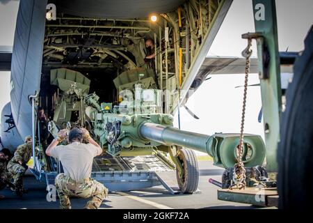 CASERME SCHOFELD, Hawaii – Soldiers from Charlie Battery “Cabras”, 2-11 Field Artillery, 25th Infantry Division Artillery ha condotto corsi di formazione per operazioni congiunte con il 41° Airlift Squadron, US Air Force from Little Rock, Arkansas, caricando un howitzer M777 su un velivolo C130J alla base aerea di Hickham, Hawaii il 06 aprile 2021. Questa formazione ha aumentato la disponibilità collettiva dei soldati, e ha consentito a ogni ramo di servizio di comprendere le tattiche, le tecniche, le procedure e le capacità reciproche in preparazione alle future operazioni congiunte. Foto Stock