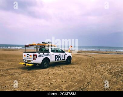 Un veicolo RNLI 4 x 4 fuoristrada che pattina una spiaggia britannica e una località balneare Foto Stock