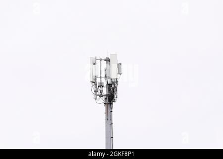 Un albero di comunicazioni telefoniche mobili visto con un cielo bianco chiaro su Belfast, Irlanda del Nord. Foto Stock