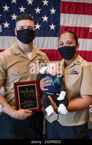 210408-N-AZ907-0028 (8 aprile 2021) NORFOLK, Va. — Information Systems Technician 1st Class Ruth Freeman, The Navy Safe Harbor Foundation Wired Warrior of the Year, pone per una foto con suo marito e suo figlio, dopo una cerimonia di premiazione a bordo della base navale di Norfolk, 8 aprile. Freeman partecipa attivamente ad atletica adattiva, tra cui l'USO Outdoor Adventure Team e i Warrior Games, e rappresenterà il Team US ai prossimi Invictus Games. Foto Stock