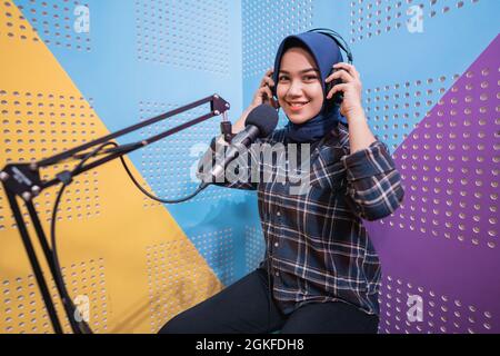 Una ragazza vlogger sta registrando un podcast in studio Foto Stock