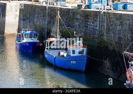Porthleven, Cornovaglia, 14 settembre 2021, la gente era fuori godendo il sole glorioso a Porthleven, Cornovaglia mentre le barche di pesca sono state ormeggiate alla banchina mentre la marea si è recata nel porto. La temperatura era 18C, la previsione è per gli intervalli di sole per i prossimi giorni.Credit: Keith Larby/Alamy Live News Foto Stock