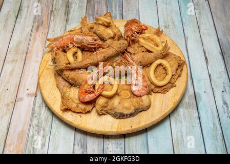 Pesce fritto popolare in pastella, gamberi alla griglia, anelli di calamari, triglie rosse martellate e nasello affettato. Foto Stock