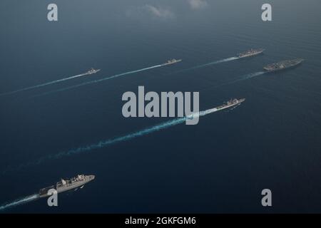 SOUTH CHINA SEA (9 aprile 2021) il gruppo Theodore Roosevelt Carrier Strike Group transita in formazione con il Makin Island Amphibious Ready Group nel South China Sea 9 aprile 2021. Il Theodore Roosevelt Carrier Strike Group, il Makin Island Amphibious Ready Group e l'incrociatore missilistico guidato di classe Ticonderoga USS Port Royal (CG 73) stanno conducendo operazioni di forza d'attacco rapida durante le loro dispiegazioni nell'area operativa della 7a flotta. Come la flotta più grande della Marina degli Stati Uniti, 7th Fleet opera e interagisce di routine con 35 nazioni marittime mentre conducendo missioni per la prefinale Foto Stock