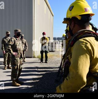 I vigili del fuoco Hotshot della 30a ala spaziale spiegano come il team estingue i fuochi a pennello al Gen. John F. Thompson, comandante del Centro spaziale e dei sistemi missilistici della forza spaziale statunitense, 9 aprile 2021, presso la base dell'aeronautica militare Vandenberg, California, a causa della posizione della base militare Vandenberg AFB, Gli incendi di terre selvatiche sono un evento comune durante i mesi estivi e gli Hotshots svolgono un ruolo importante nel mantenere l'installazione pronta e in grado di continuare la missione. Foto Stock