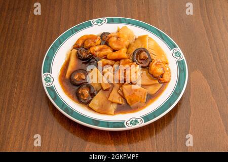 Ricetta ristorante cinese con bambù tritato, gamberi sbucciati stufati e funghi cinesi con salsa di soia su tavola di legno Foto Stock
