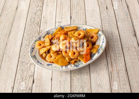 ottimo servizio di gamberi con funghi, bambù, carote e verdure condite con salsa di soia su tavola di legno Foto Stock