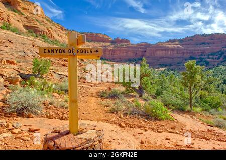 Un cartello in legno che indica l'inizio di un percorso al di sotto di Mescal montagna vicino a Sedona in Arizona che è apparentemente solo per gli stolti. Foto Stock