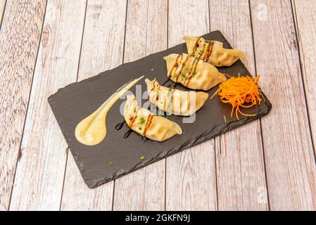 Gnocchi cinesi al vapore, dim sum, conditi con salsa di soia e carota per guarnire Foto Stock