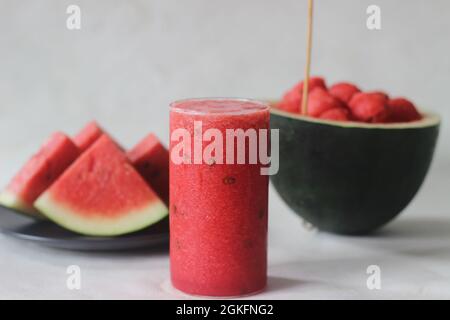 Succo di cocomero fresco preparato a casa. Il suo bene per mantenere il vostro corpo fresco dal calore estivo. Sparato con acqua melone scoop e fette su bianco Foto Stock