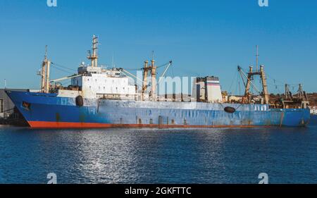 La nave Trawler con scafo blu è ormeggiata nel porto norvegese in una giornata di sole Foto Stock