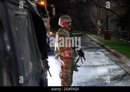 I soldati della Guardia Nazionale del Minnesota si levano in guardia, rafforzando gli sforzi locali di applicazione della legge nel Brooklyn Center, Minnesota il 13 aprile 2021, la notte dopo i primi disordini scoppiati nella zona. Oltre 2,000 Airmen e soldati sono stati attivati a sostegno di Operation Safety Net, uno sforzo coordinato per proteggere i diritti dei manifestanti pacifici e garantire la sicurezza del pubblico durante il processo di Derek Chauvin. Le organizzazioni che partecipano a Operation Safety Net sono impegnate a proteggere le persone, le proprietà e la libertà di parola.​ Foto Stock